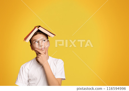 Pensive boy with book on head thinking on orange background, panorama with copy space Pensive boy with book on head thinking on orange background, panorama with copy space 116594996