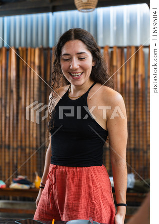 Young teacher looking at her children's work happily during back to school. Vertical 116595041