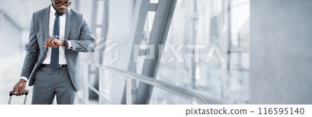 African American Businessman Checking Time On Watch, Walking In Airport, Cropped, Panorama With Copy Space 116595140