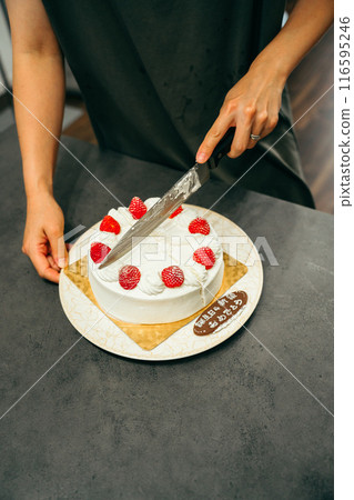 Woman's hands cutting a cake 116595246