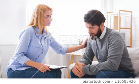 Professional psychologist comforting sad depressed male patient at personal consultation in office Professional psychologist comforting sad depressed male patient at personal consultation in office 116595426