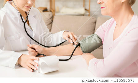 Doctor measuring arterial blood pressure for senior woman patient. Health care in hospital, empty space Doctor measuring arterial blood pressure for senior woman patient. Health care in hospital, empty space 116595575