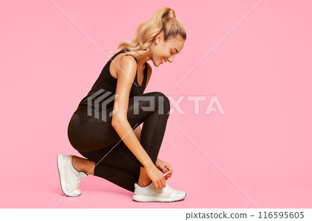 Happy Fitness Woman Lacing Shoes Before Workout Training On Yellow Studio Background. Free Space Happy Fitness Woman Lacing Shoes Before Workout Training On Yellow Studio Background. Free Space 116595605