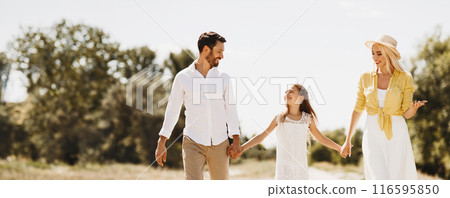 Happy family walking on path holding hands and spending time in countryside Happy family walking on path holding hands and spending time in countryside 116595850