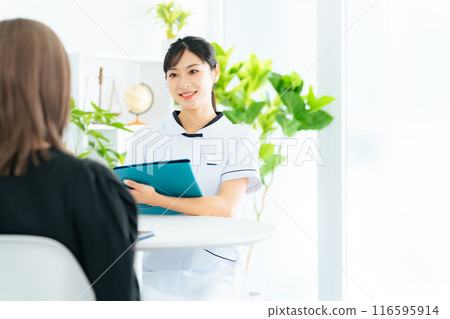 A female medical worker interviewing a patient 116595914