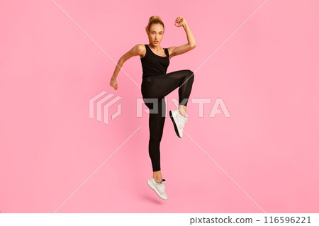 Workout. Serious Fitness Woman Jumping While Exercising On Yellow Background. Studio Shot Workout. Serious Fitness Woman Jumping While Exercising On Yellow Background. Studio Shot 116596221