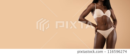 Well fit body of unrecognizable african american woman posing over beige studio background, dark skinned model in underwear showing her curves, cropped, panorama with copy space Well fit body of unrecognizable african american woman posing over beige studio background, dark skinned model in underwear showing her curves, cropped, panorama with copy space 116596274