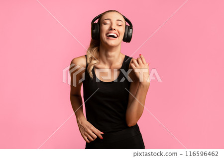 Happy Fitness Girl In Headphones Listening To Music And Dancing During Workout On Yellow Background. Studio Shot Happy Fitness Girl In Headphones Listening To Music And Dancing During Workout On Yellow Background. Studio Shot 116596462