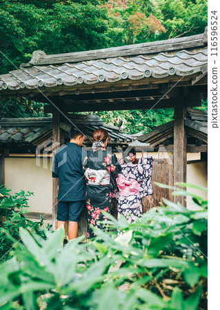 The back of a woman standing in front of the gate of Shunpu Manri-so The back of a woman standing in front of the gate of Shunpu Manri-so 116596524