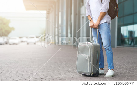 Waiting For Transfer. Unrecognizable Man Standing Near Airport Terminal With Luggage, Cropped Image, Panorama With Empty Space 116596577