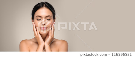 Calm positive pretty young european woman with perfect skin and closed eyes, touching hands to face, isolated on gray background. Basic makeup, beauty care, routine or spa treatment, copy space Calm positive pretty young european woman with perfect skin and closed eyes, touching hands to face, isolated on gray background. Basic makeup, beauty care, routine or spa treatment, copy space 116596581