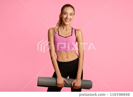 Fitness Concept. Young Woman Holding Gym Mat Smiling At Camera On Yellow Studio Background. Fitness Concept. Young Woman Holding Gym Mat Smiling At Camera On Yellow Studio Background. 116596698