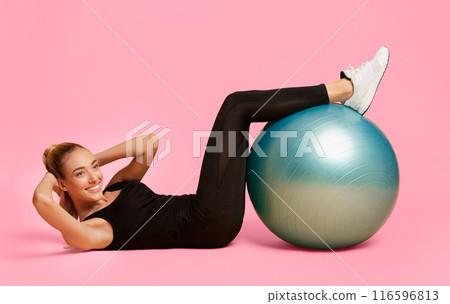 Body Shaping. Smiling Young Woman Doing Abs Exercise With Fitball On Yellow Studio Background. Body Shaping. Smiling Young Woman Doing Abs Exercise With Fitball On Yellow Studio Background. 116596813