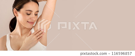 Armpit Depilation Concept. Happy Young Lady Looking At Her Smooth Underarms, Smiling Woman Wearing Underwear Standing With Hands Up Over Beige Studio Background, Copy Space 116596857