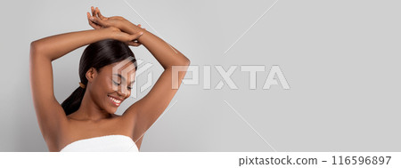 Armpit Depilation Concept. Happy Black Lady Looking At Her Smooth Underarms, Smiling African American Woman Wrapped In Towel After Bath Standing With Hands Up Over Gray Studio Background, Copy Space Armpit Depilation Concept. Happy Black Lady Looking At Her Smooth Underarms, Smiling African American Woman Wrapped In Towel After Bath Standing With Hands Up Over Gray Studio Background, Copy Space 116596897