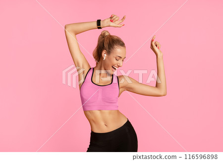 Sporty Woman In Wireless Earphones Dancing Listening To Music Over Yellow Studio Background. Free Space 116596898