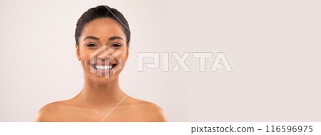 Cheerful millennial african american lady with nude makeup looking at camera, isolated on studio background, studio, close up. Beauty and skin care at home, cosmetology, fashion, copy space 116596975