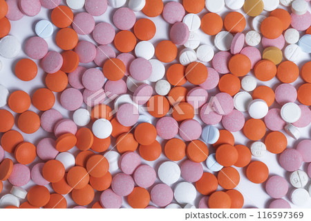 Close up of colorful round pills scattered on white background. 116597369