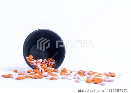 Multicolor pills spilling out of spilled from black plastic box on white background. closeup Multicolor pills spilling out of spilled from black plastic box on white background. closeup 116597371