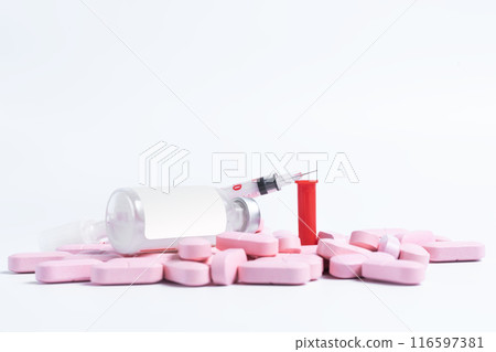Vaccine bottle with syringe on top of pink pills spilled on white background. 116597381