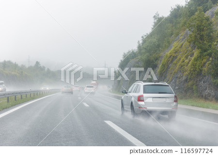 Back tail view of many cars driving fast on wet highway road after rain in Europe. Automobile accident vehicle rush hour collapse. Transportation vacation seasonal stuck 116597724