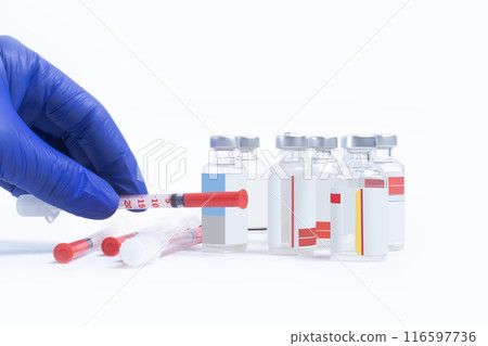 Doctor in blue gloves holds a syringe with syringe and vials on white background. Closeup 116597736