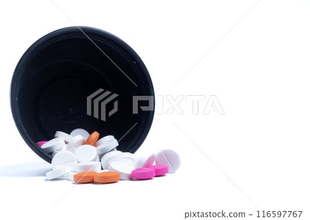 Pills spilling out of a black plastic container leaning against a white background. Medical health care concept. Pills spilling out of a black plastic container leaning against a white background. Medical health care concept. 116597767