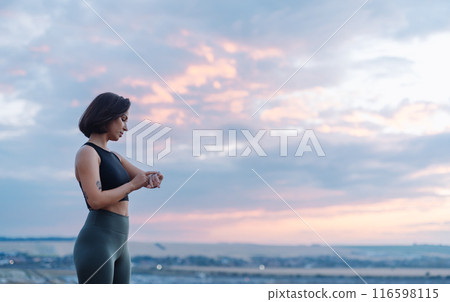 Woman dressed in activewear peacefully enjoying the breathtaking sunset outdoors 116598115