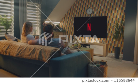 Couple starts to watch movie or TV show on Netflix sitting on sofa at home Couple starts to watch movie or TV show on Netflix sitting on sofa at home 116598644