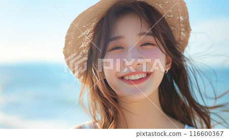 Close-up of a smiling woman's face with a bright ocean background 116600367