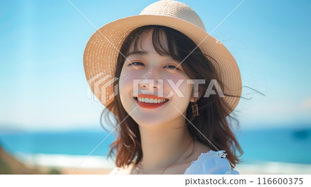 Close-up of a smiling woman's face with a bright ocean background 116600375