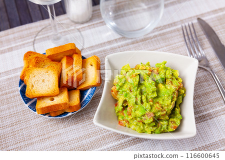 Guacamole and toasted bread served on white plate Guacamole and toasted bread served on white plate 116600645
