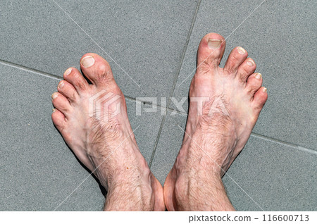 Bare legs of a man. Naked male legs on tile floor with copy space. Bare legs of a man. Naked male legs on tile floor with copy space. 116600713