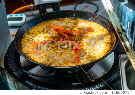 Meat and seafood paella cooked in frying pan 116600734