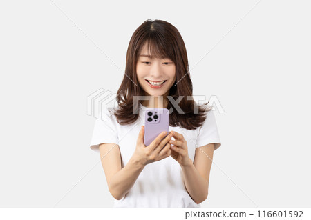 A smiling Japanese woman operating a smartphone A smiling Japanese woman operating a smartphone 116601592