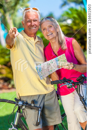 Happy Senior Couple on Bicycles In a Park Using a Map and Pointing 116601903