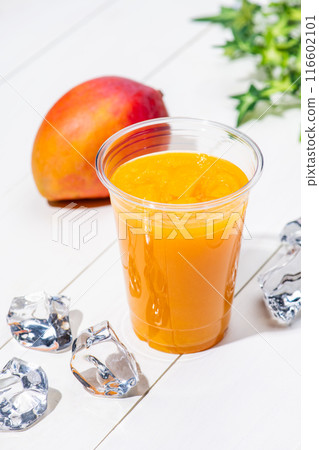 Mango smoothie in a plastic cup on a white table Mango smoothie in a plastic cup on a white table 116602101