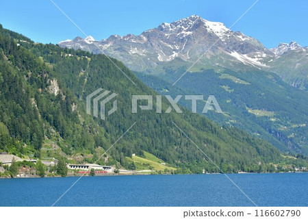 The lake, mountains and remaining snow create a magnificent sight. 116602790