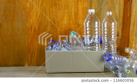 Waste plastic bottles on wooden background waiting for recycling concept of saving our environment sustainable natural resources. 116603056