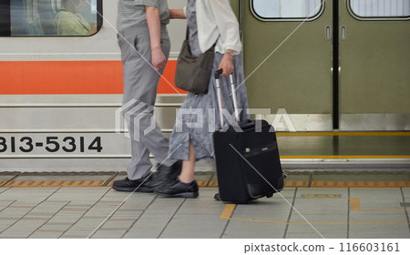 Senior couple walking on a train platform in summer Senior couple walking on a train platform in summer 116603161