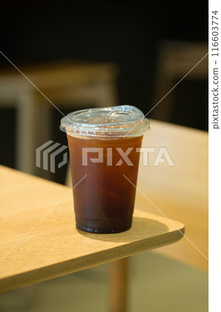 Cold brew coffee in a clear cup on wood. Cold brew coffee in a clear cup on wood. 116603774