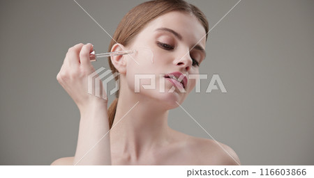 Beauty, health, cosmetics, anti-aging therapy and skin care concept - young beautiful brunette Caucasian woman applying cosmetic serum from a pipette for facial skin care Beauty, health, cosmetics, anti-aging therapy and skin care concept - young beautiful brunette Caucasian woman applying cosmetic serum from a pipette for facial skin care 116603866