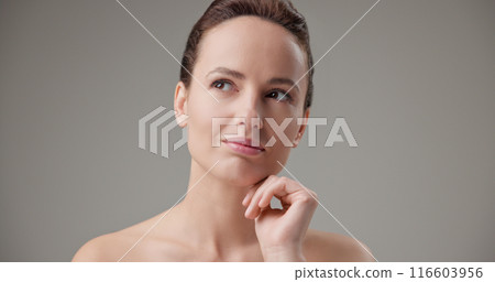 Concept of beauty, health, cosmetics, anti-aging therapy and skin care - young beautiful brunette Caucasian woman thoughtfully looks around making difficult choice thinking through actions 116603956