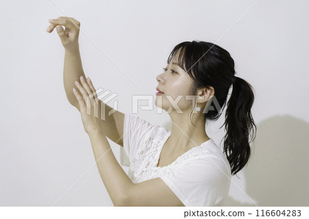 白色背景下在手臂上塗抹防曬霜的年輕女子 116604283