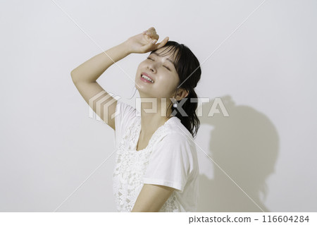 A young woman with a dazzling face on a white background A young woman with a dazzling face on a white background 116604284
