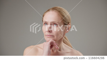 Real people - concept of age, beauty, health and dry skin care - beautiful mature Caucasian middle-aged woman in her 50s pondering a difficult choice, looking around in doubt Real people - concept of age, beauty, health and dry skin care - beautiful mature Caucasian middle-aged woman in her 50s pondering a difficult choice, looking around in doubt 116604286