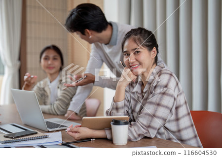 Group of Diverse Student Collaboration on a Project in a Modern Classroom Setting with Laptops and Notebooks 116604530