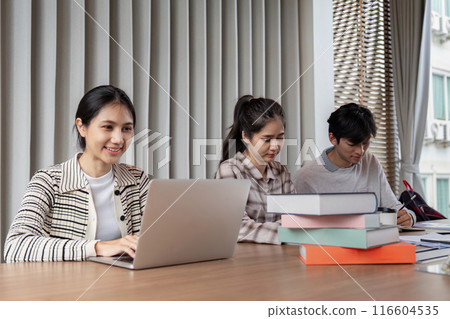 Group of Focused Student Study Together with Laptops and Books in a Modern Classroom Setting 116604535