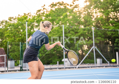 Professional female tennis player playing in tennis with racket and ball on outside court at sunset light Professional female tennis player playing in tennis with racket and ball on outside court at sunset light 116606110