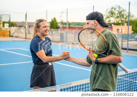 Professional tennis players shaking hands at the end of a tennis game on outside court 116606122
